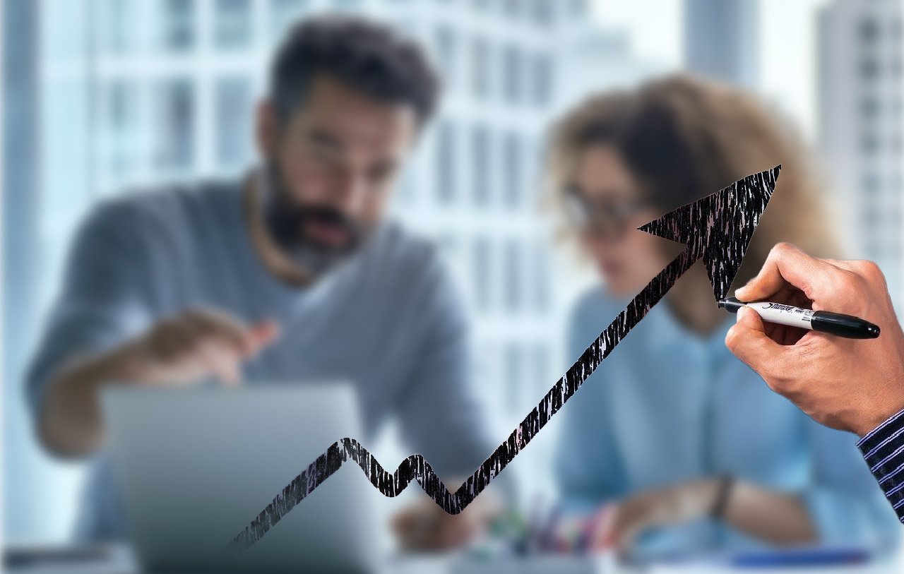 3 Ways Effective Coaching Unlocks Potential. Image shows an arrow pointing upward and to the right over a blurred image of a man coaching a woman on a laptop.